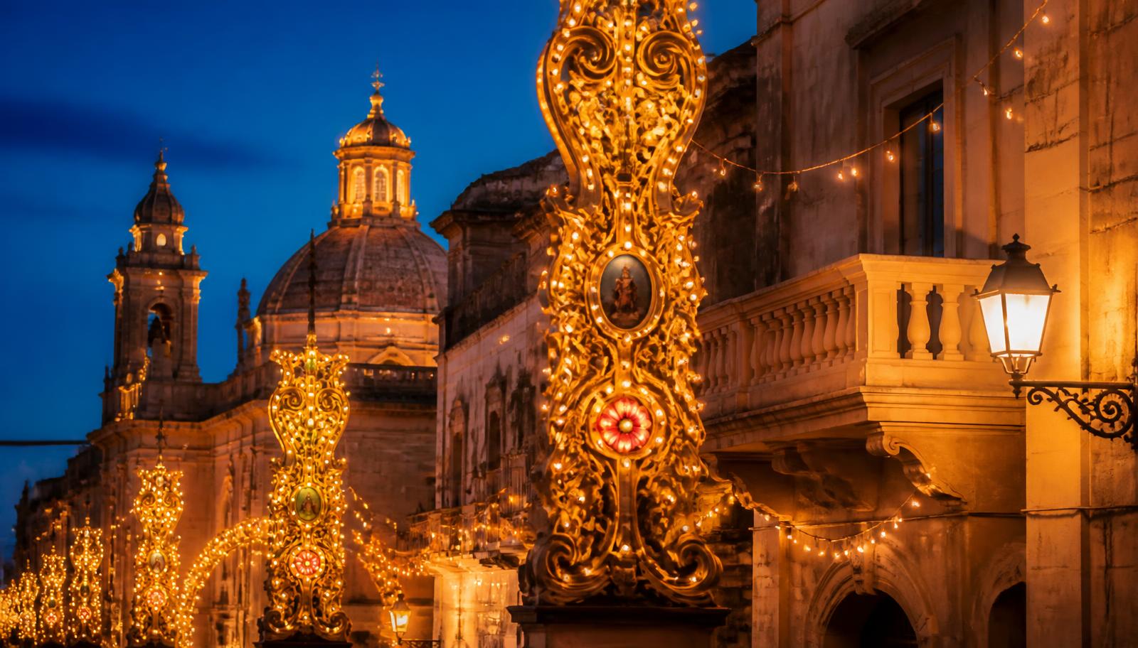 Illuminated golden feast decorations along a Maltese village street at dusk